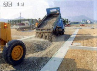 上層路盤材を次々と搬入